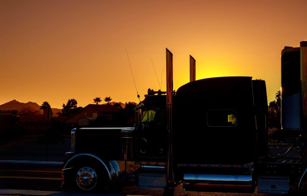 Image of truck at sunset to illustrate that idling can damage the aftertreatment system and increase regens. 